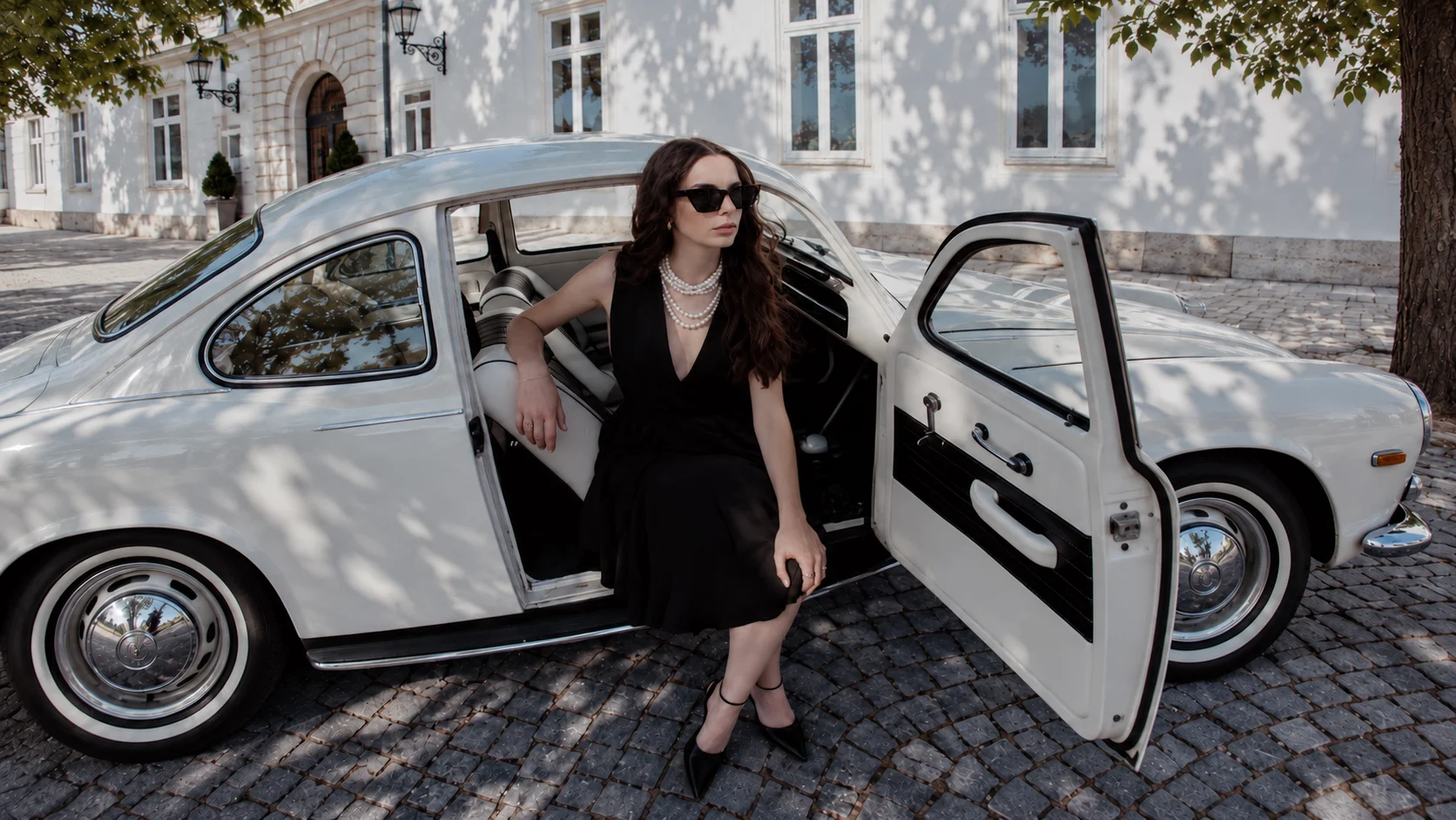 Campanha Sitrin — vestido preto junto a um automóvel clássico